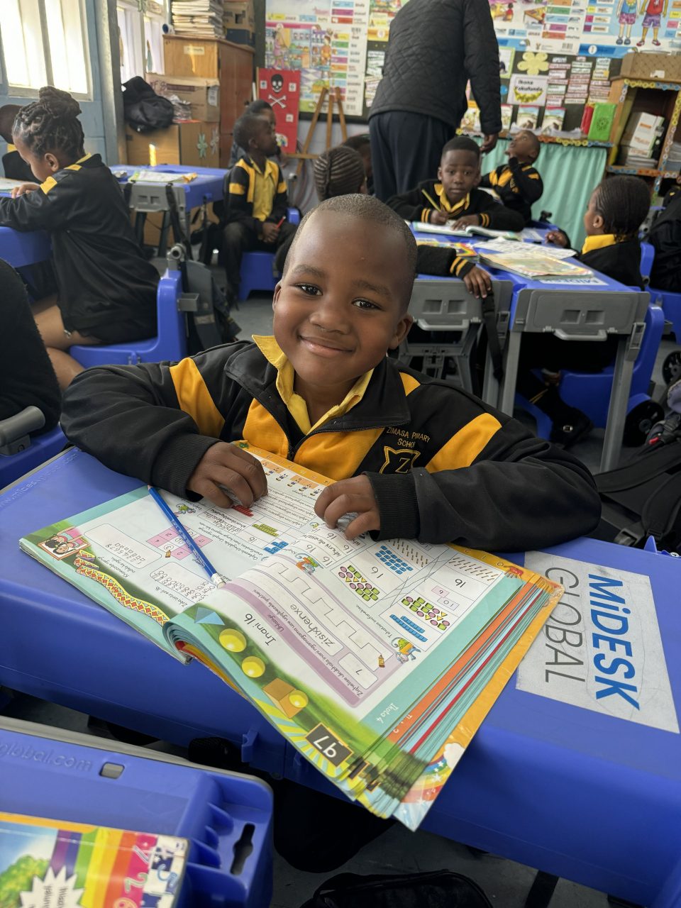 South African learner using portable desk solution in classroom to improve learning conditions
