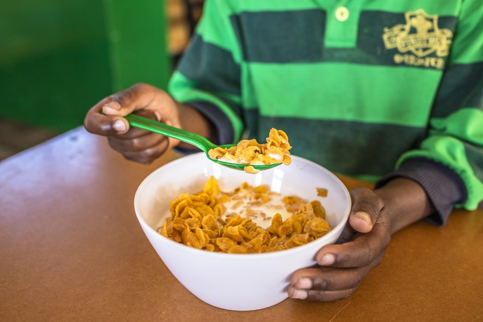 South African learner eating cereal breakfast at school