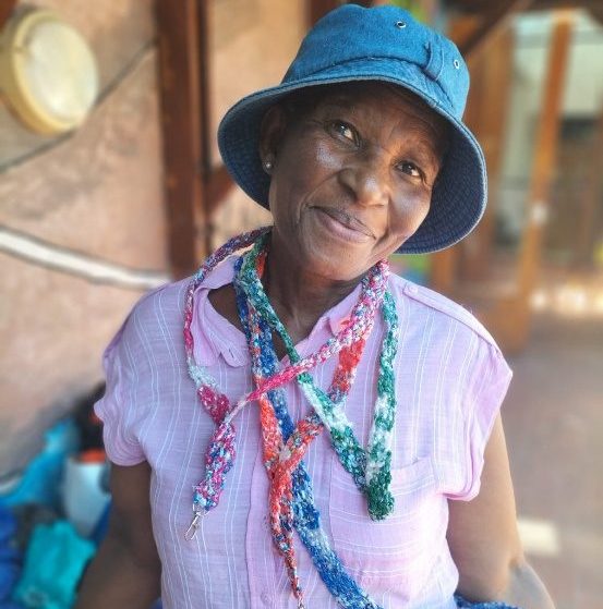 Woman wearing handmade lanyards created from recycled bread bags as part of a sustainable Re.Bag.Re.Use initiative