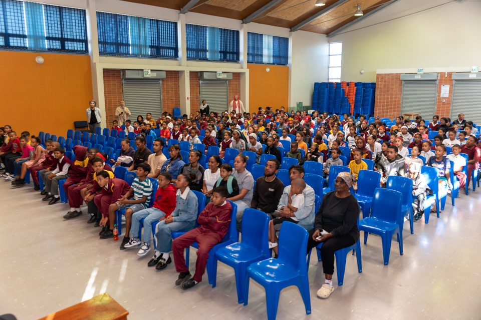 Learners and community members seated in a school hall during a Junior River Wardens graduation ceremony in Manenberg.