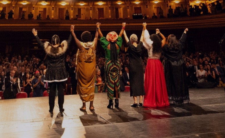 Six women winners of the 2026 Goldman Environmental Prize standing together on stage with raised hands