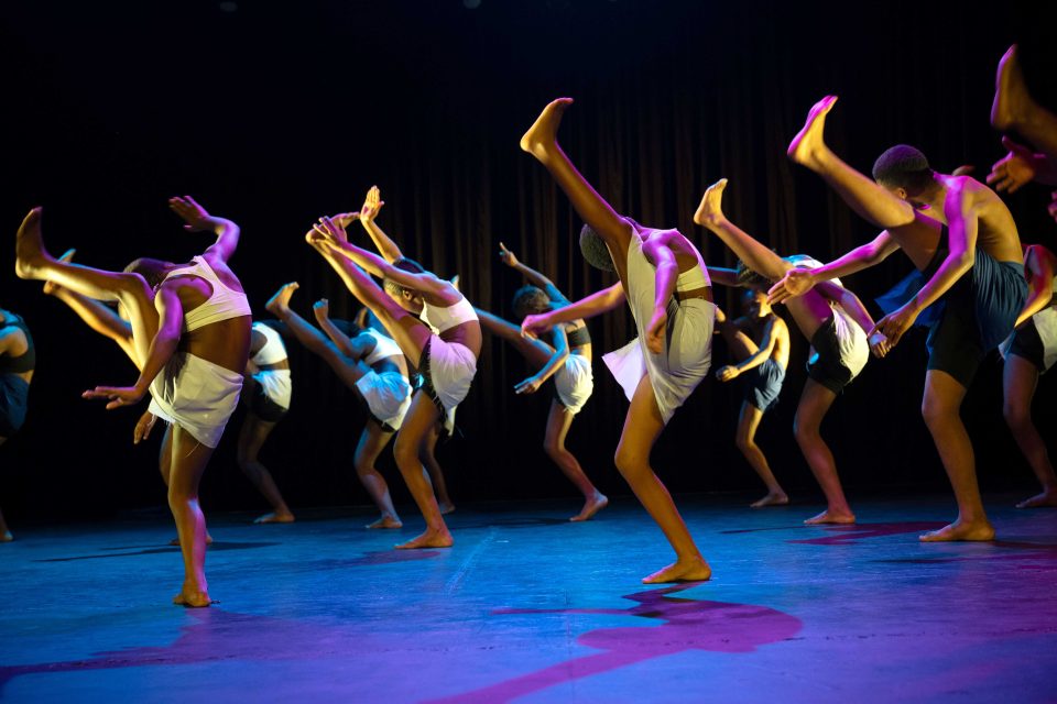 Young dancers performing on stage during a contemporary dance showcase