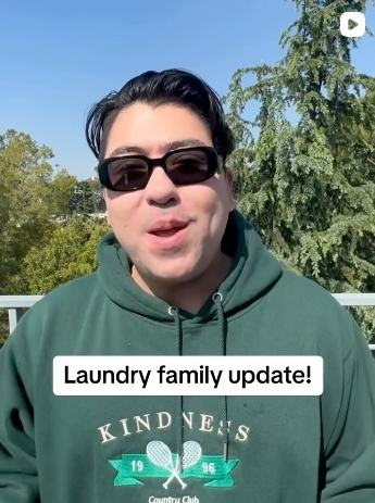 Isaiah Garza speaks in a social media update video while wearing a green hoodie promoting kindness and community support initiatives.