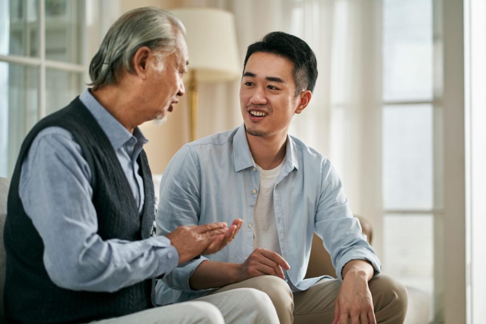 Adult child visiting elderly parent at home in a warm family setting