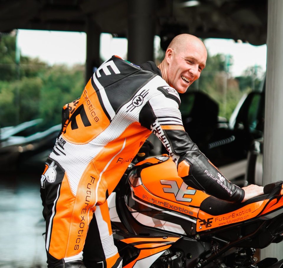 South African motorcycle racer AJ Venter stands beside his FuturExotics-backed superbike ahead of international road racing competition.