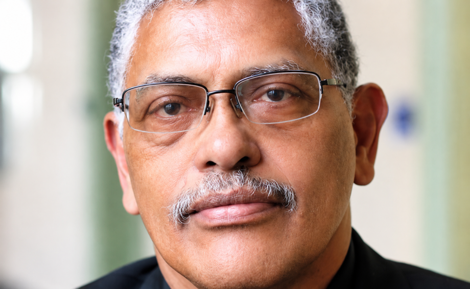 Portrait of a professional man wearing glasses, looking directly at the camera in an indoor setting.