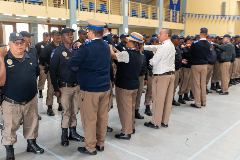 Metro Police officers stand in formation during a rank promotion ceremony as senior officials formally present new sergeant and inspector insignia.
