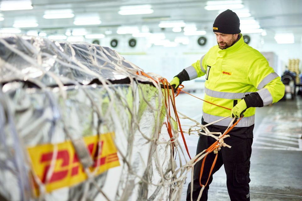 A DHL logistics specialist secures humanitarian cargo as part of disaster preparedness and logistics operations.