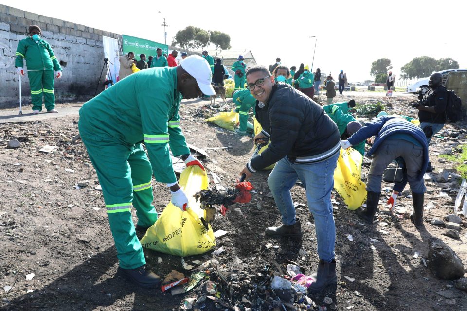 Community volunteers and City of Cape Town officials remove litter during a clean-up campaign at the Gugulethu Canal to reduce illegal dumping and flooding.