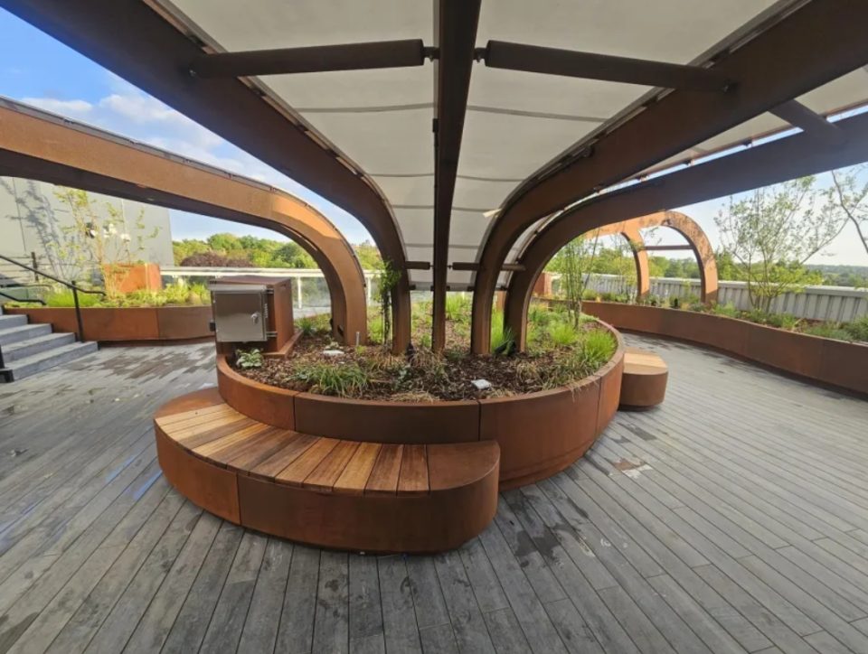 A rooftop critical care garden at King's College Hospital in London featuring landscaped greenery, seating and sheltered walkways designed to support patient recovery.