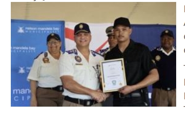 A newly trained Tourism Safety Officer receives a certificate during a graduation ceremony attended by Nelson Mandela Bay municipal and law enforcement officials.