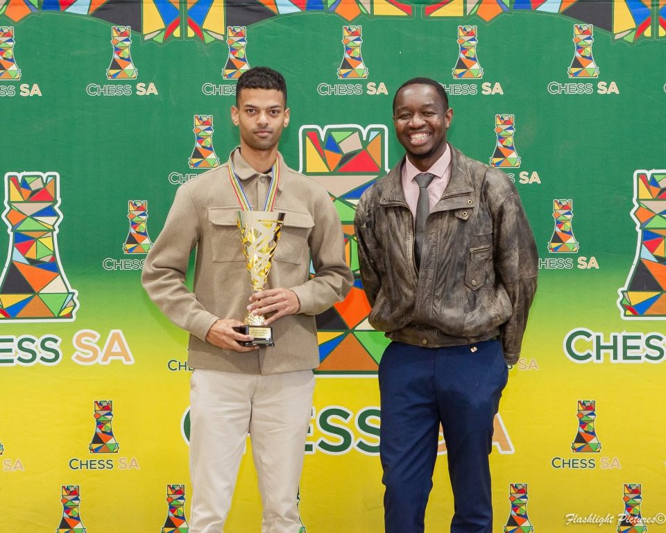 University of the Western Cape PhD student Harrison Abrahams holds his South African Open Chess Championships Intermediate Section trophy alongside a fellow participant at the Chess SA awards ceremony.