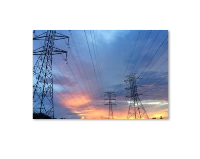 Electricity transmission towers and power lines at sunset, representing Eskom’s progress in removing more than one million customers from load reduction schedules.