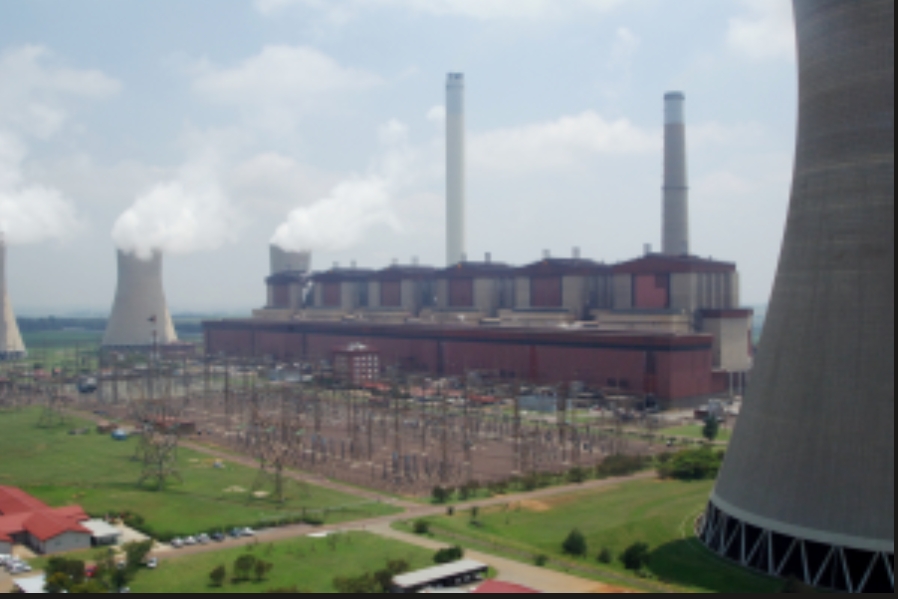 A large power station with cooling towers and industrial infrastructure, illustrating the importance of research into air pollution and its impact on public health.