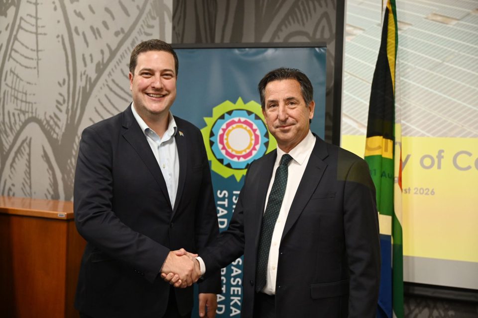 Two representatives shake hands at an event marking Cape Town’s first independent power purchase agreements.