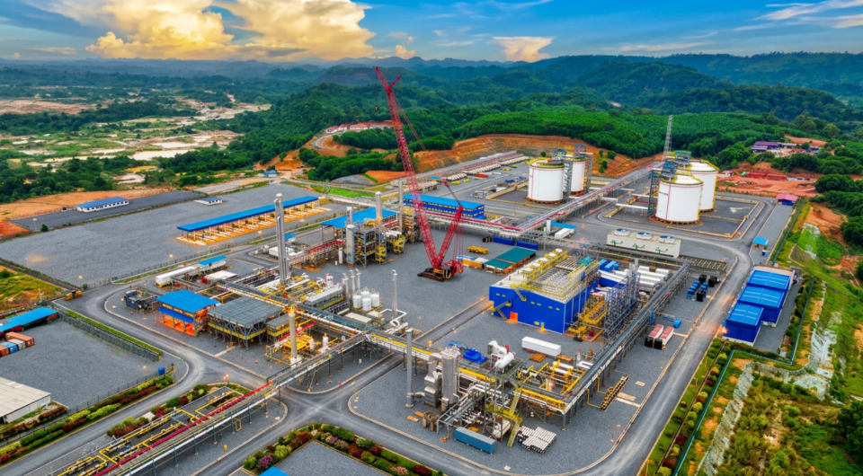 Aerial view of Genser Energy infrastructure featuring processing facilities, storage tanks and industrial equipment surrounded by green landscape.