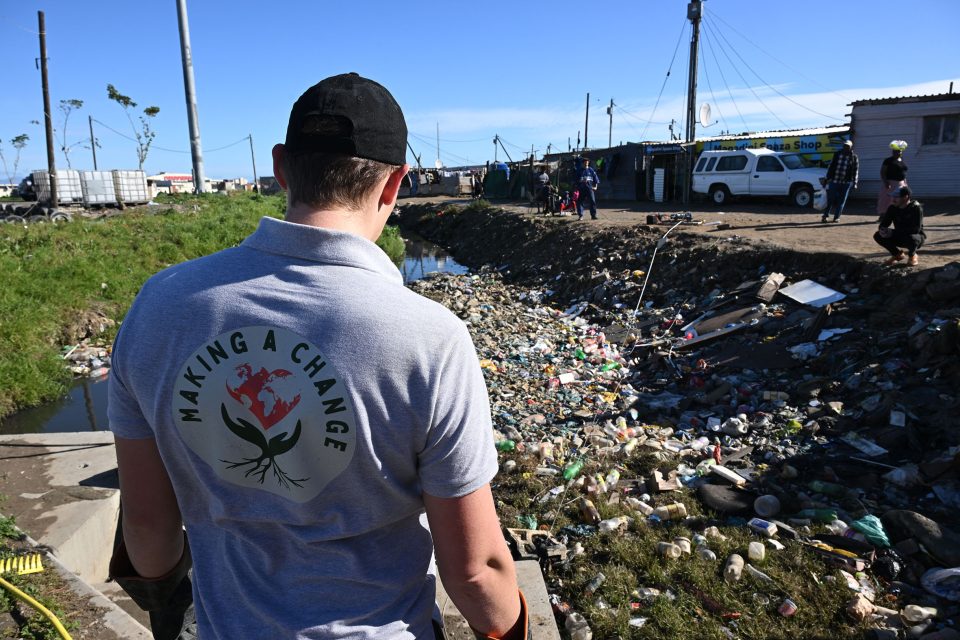Making a Change team member overlooks heavy litter pollution along the Soet River before community clean-up and restoration work.