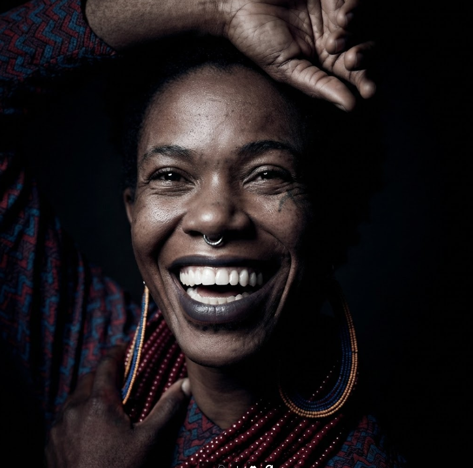 Smiling poet and performer photographed in a dramatic portrait, representing the voices and creative expression celebrated at Poetry Africa 2026.