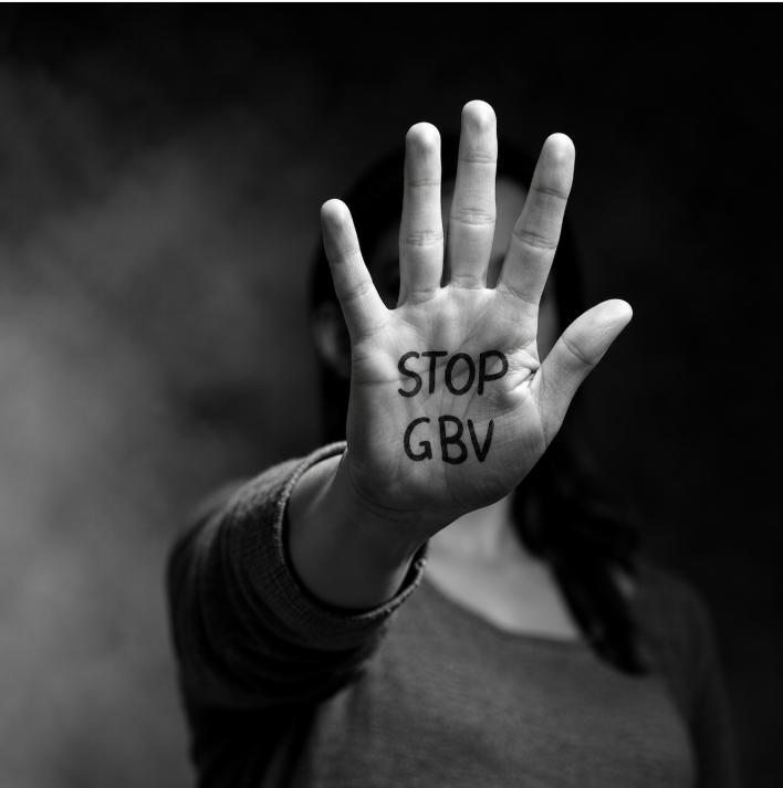 Black-and-white image of a woman raising her hand with “STOP GBV” written on her palm, symbolising resistance to gender-based violence.