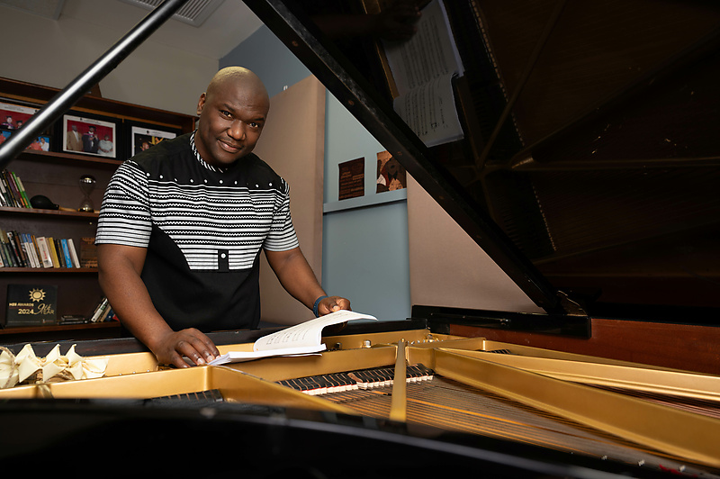 South African pianist and composer Dr Sibusiso “Mash” Mashiloane with a grand piano and sheet music.