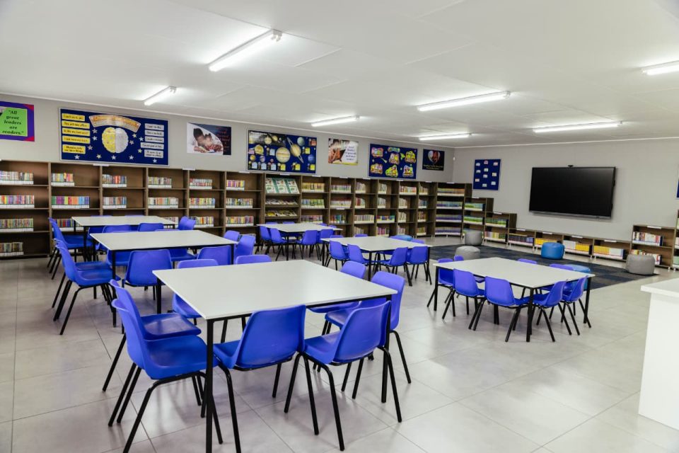 DP World and Motus 100th school library at Katlehong Primary School, featuring bookshelves, reading tables, chairs and educational resources.