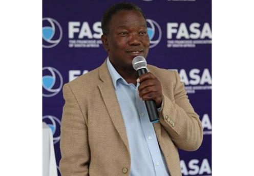 FASA representative speaking at an industry event with Franchise Association of South Africa branding in the background.