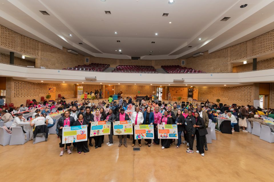 Participants and early childhood development stakeholders gather at Kraaifontein Civic Centre for the City of Cape Town's Regional ECD Conversations, with representatives holding posters highlighting key development priorities.